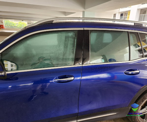 Blue sedan post-fumigation in a covered carpark